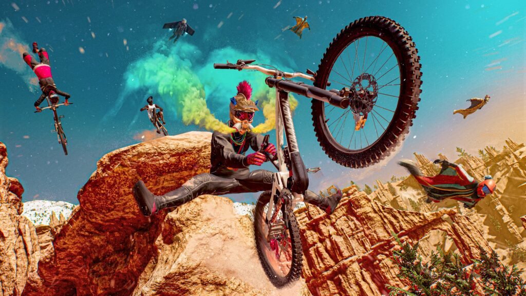 A dynamic and colorful screenshot from Riders Republic showing multiple extreme sports athletes performing tricks simultaneously in a vast, mountainous landscape with a partly cloudy sky.