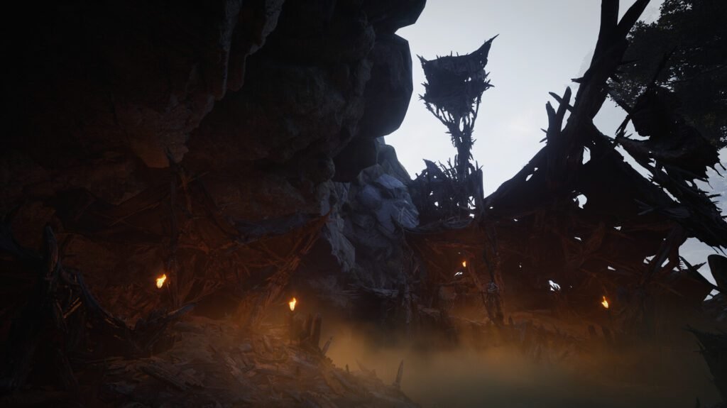 : A dark, spiked wooden structure illuminated by torches inside a rocky cavern