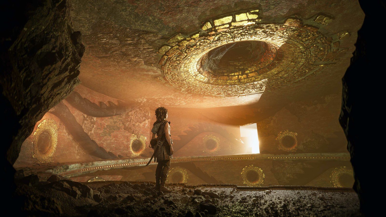 Character in a cave illuminated by a golden ceiling with spiral motifs