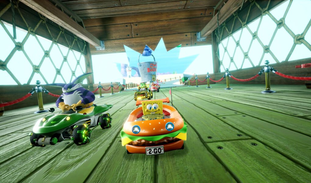 SpongeBob driving the Patty Wagon in a race inside a wooden boardwalk area.