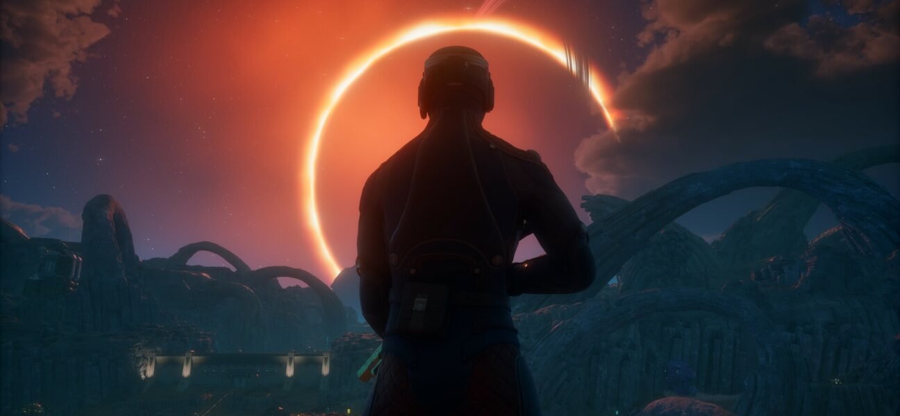 A silhouetted astronaut overlooks an alien landscape with a glowing eclipse.